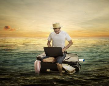 Die beste Charter-Folgeschadenversicherung finden Mann sitzt auf schwimmendem Koffer und sucht Charter-Folgeschadenversicherung