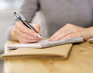 Die Prüfung vom Sportküstenschifferschein Prüfung Sportküstenschifferschein: Frau macht Notizen