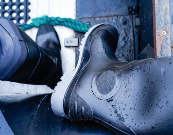 Nasse Segelstiefel an Bord eines Bootes