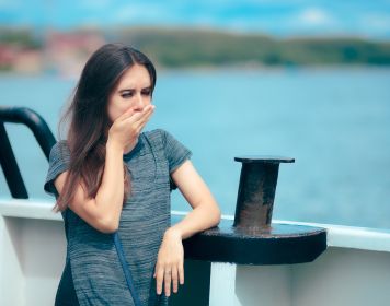 Die Seekrankheit kann jeden treffen Frau an Bord eines Schiffs leidet unter der Seekrankheit