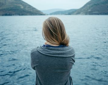 Mittel gegen Seekrankheit: Frau starrt auf Wasser