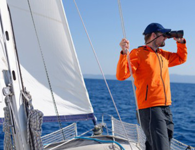 Mann mit typischer Segelausrüstung und -bekleidung