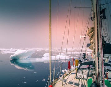 Segeln rund um die Arktis Segeln Arktis: Yacht umgeben von Eisschollen