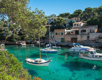 Segeln um die Balearen Segelboote ankern im azurblauen Wasser der Balearen