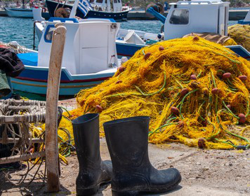 Ein Paar Segelstiefel vor einem Fischernetz